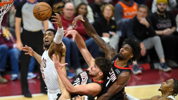 Cavaliers guard Donovan Mitchell and center Jarrett Allen reach for a rebound beside Rockets center Alperen Sengun and forward Tari Eason.
